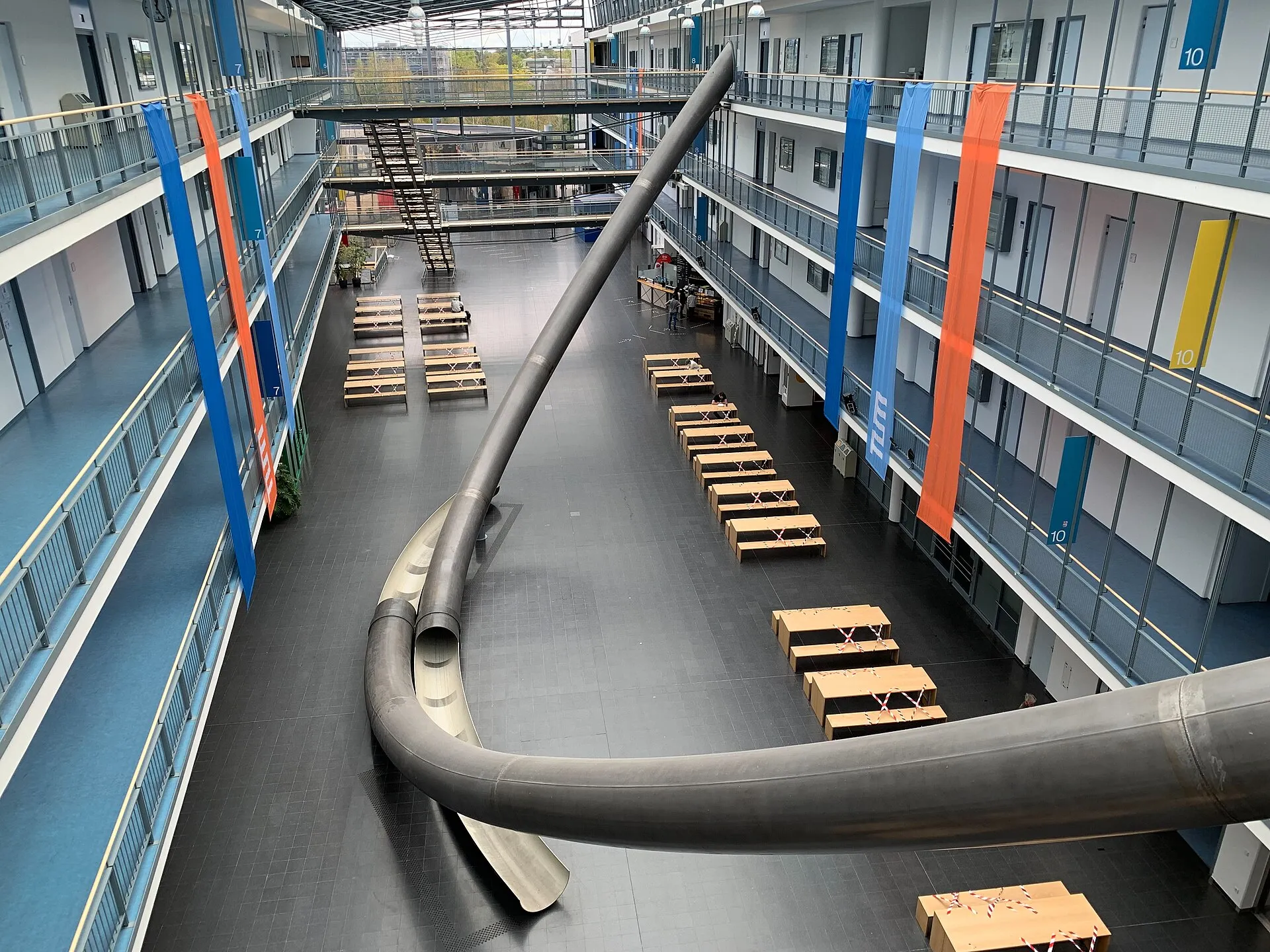 The atrium of the TUM Mathematics and Informatics building in Garching, its parabolic slides sweeping down four floors